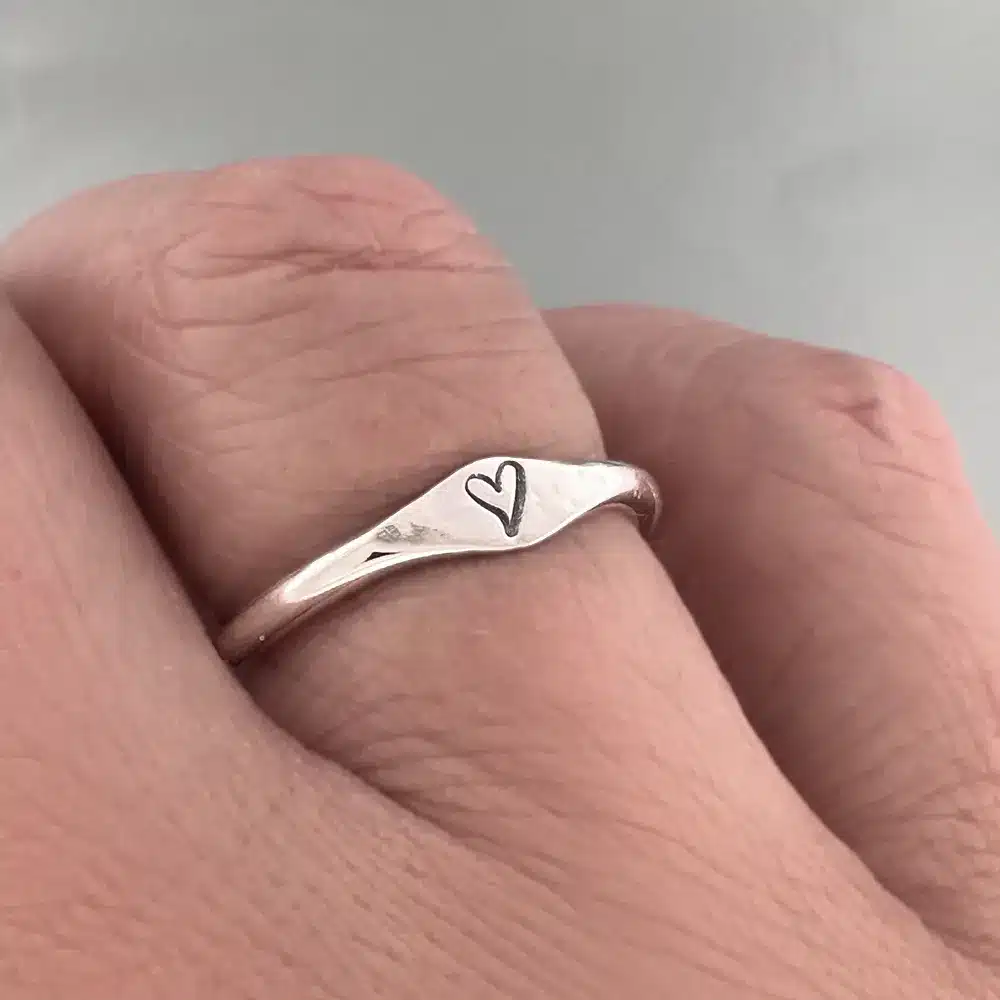 enkel håndlaget sølvring stemplet med ett lite hjerte